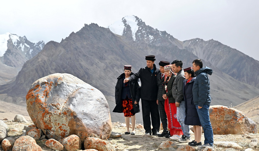 2023年9月21日，在瓦罕走廊，一家四代護(hù)邊的龍吉克·卡德爾（左二）在向家人講述家訓(xùn)石的故事。新華社記者 李響 攝